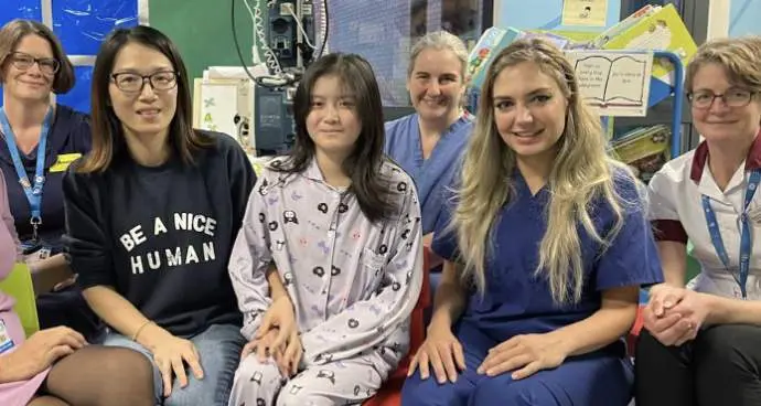  Kai Xue con su madre y miembros del equipo de los Hospitales Universitarios de North Midlands - NHS Trust via SWNS 