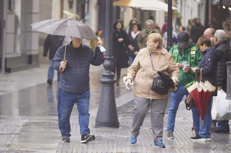  Un hombre aguanta su paraguas para que el viento no lo vuele durante la llegada de la borrasca Efra&iacute;n a C&aacute;diz 
