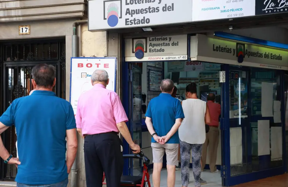  Archivo - Colas para comprar Loter&iacute;a en una administraci&oacute;n de Loter&iacute;as y Apuestas del Estado ubicada en el centro de Sevilla. A 12 de agosto de 2024, en Sevilla (Andaluc&iacute;a, Espa&ntilde;a). - ROC&Iacute;O RUZ / EUROPA PRESS - Archivo 