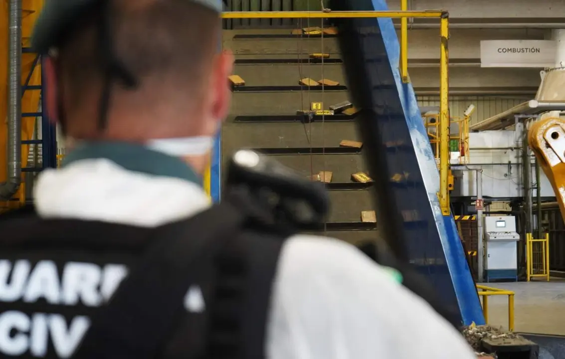  Un agente de la Guardia Civil supervisa droga que se dirige a una m&aacute;quina de combusti&oacute;n para ser destruida. - MINISTERIO DEL INTERIOR 