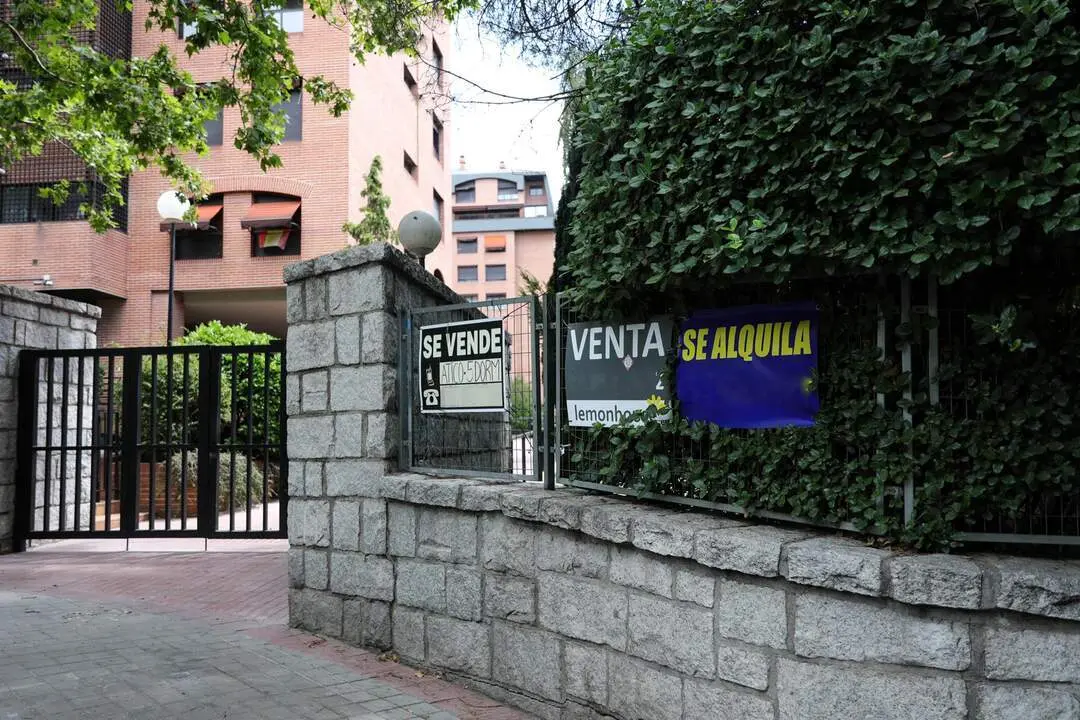  En la valla de una urbanizaci&oacute;n, se ven colgados dos carteles de 'Se vende piso' y uno de 'Se alquila' 