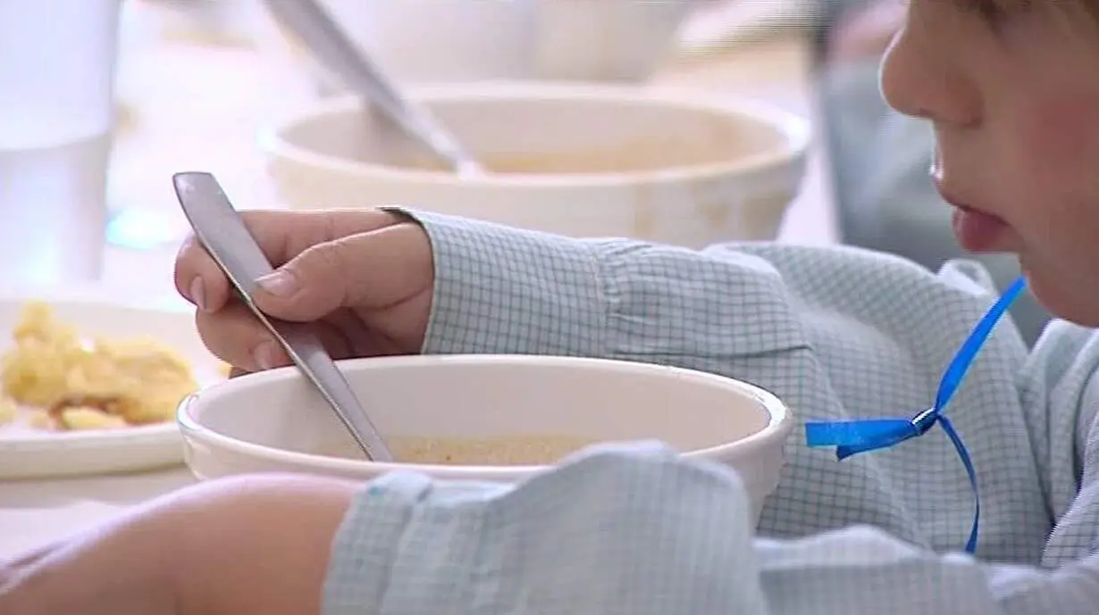  Ni&ntilde;o comiendo en un comedor escolar 