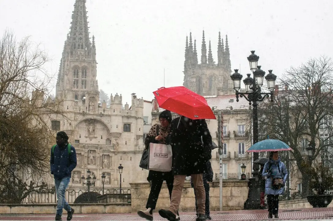  Varias personas caminan por la calle mientras nieva, a 23 de febrero de 2023, en Burgos, Castilla y Le&oacute;n (Espa&ntilde;a). - Tom&aacute;s Alonso - Europa Press 