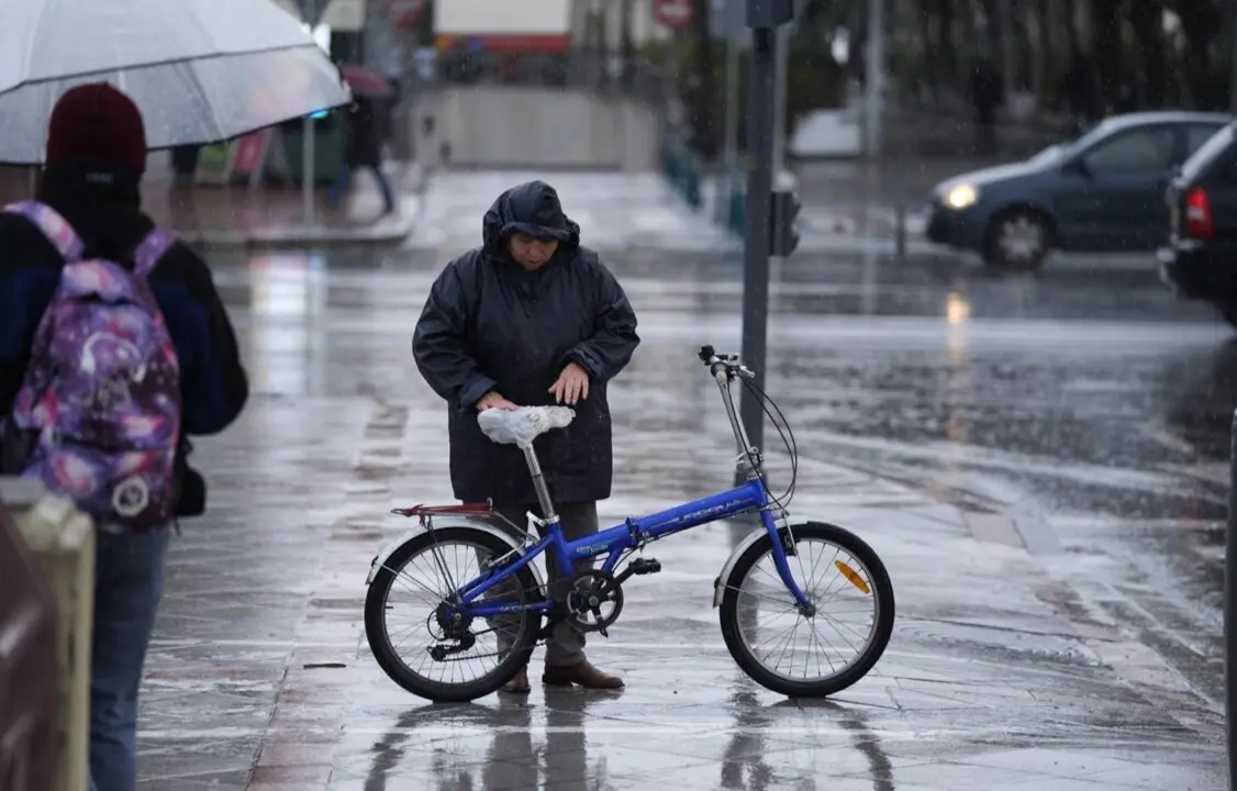  Una persona se protege de la lluvia con un impermeable en Sevilla. - Joaquin Corchero - Europa Press 
