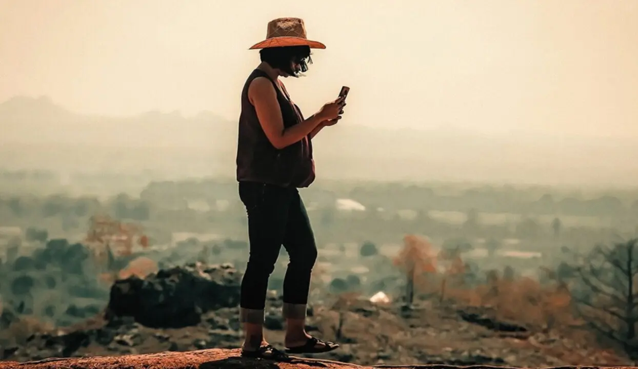  Una viajera intenta realizar una llamada con su tel&eacute;fono m&oacute;vil. 