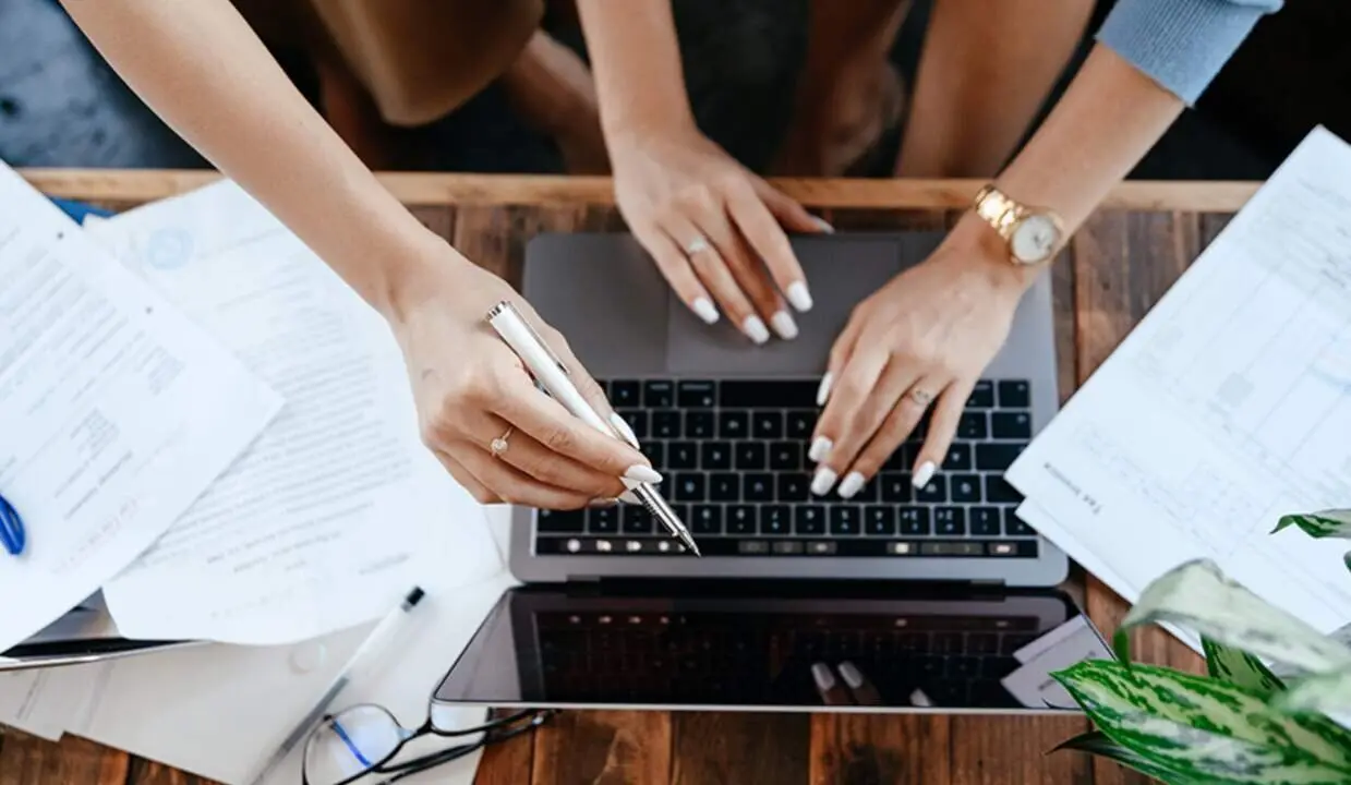  Trabajadores consultan un dispositivo port&aacute;til. 