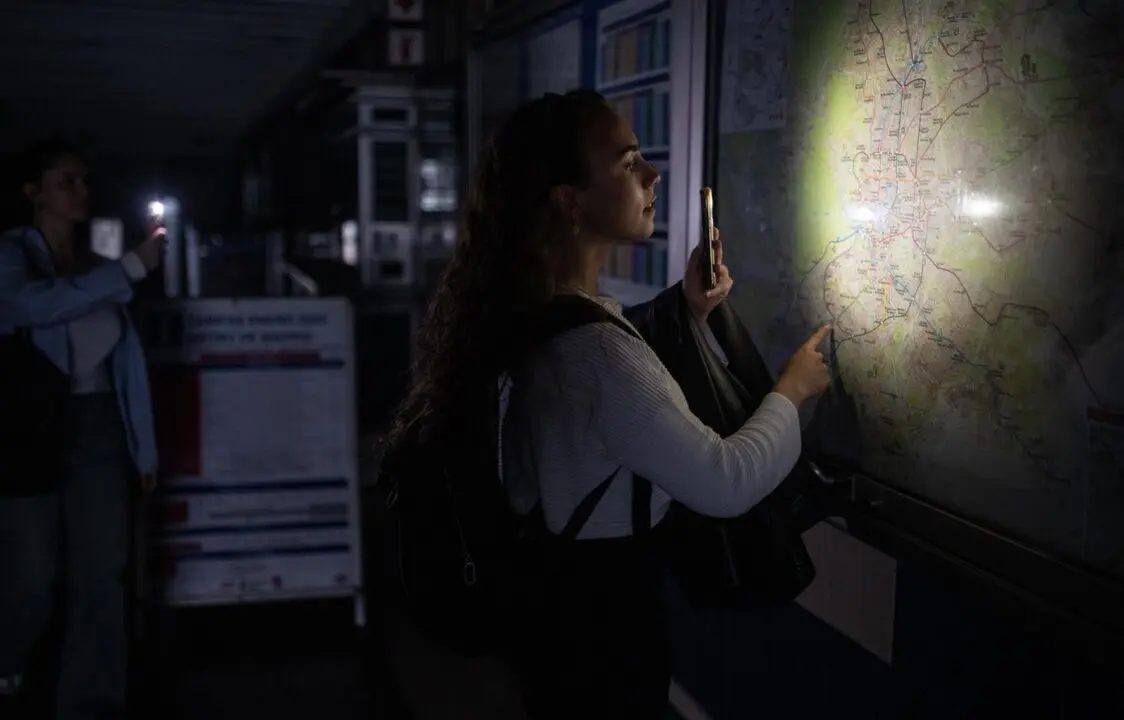  Una mujer ilumina con la linterna del m&oacute;vil un plano de la red de Metro de Madrid en una estaci&oacute;n, el 28 de abril de 2025 en Madrid, Espa&ntilde;a. - Alejandro Mart&iacute;nez V&eacute;lez/Europ / Europa Press 