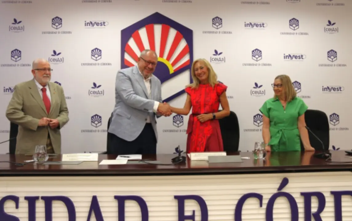  El rector y la presidenta de la AECC estrechan manos tras la firma del convenio. 