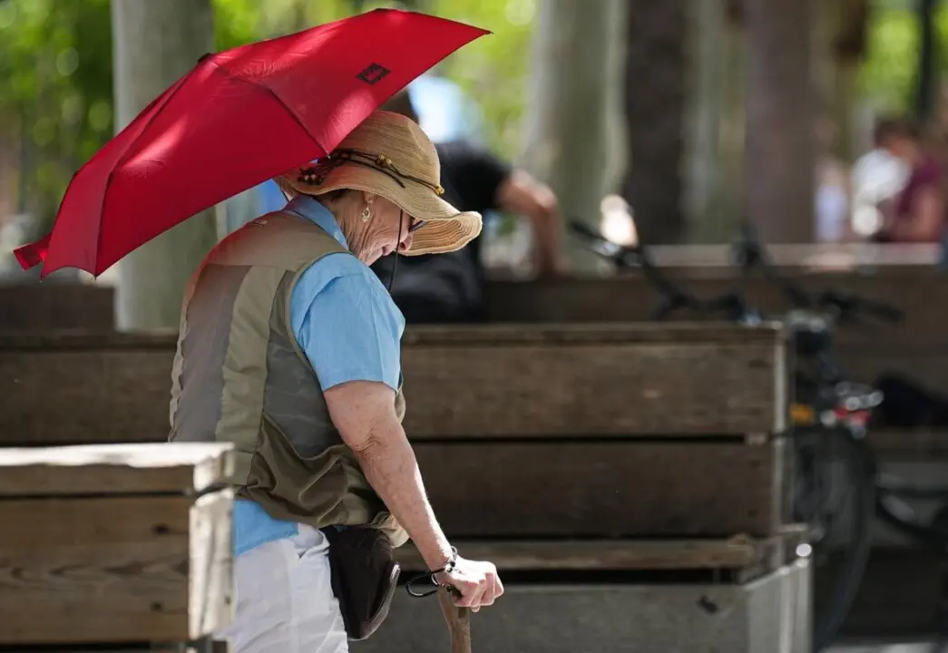  Archivo - Una mujer con sombrero y sombrilla paseando por puerta de Jerez. A 05 de julio de 2024, en Sevilla (Andaluc&iacute;a, Espa&ntilde;a). Andaluc&iacute;a afronta este martes la primera jornada de la segunda ola que se extender&aacute; hasta el jueves 25 de julio, tras la fina<br>- Mar&iacute;a Jos&eacute; L&oacute;pez - Europa Press - Archivo 