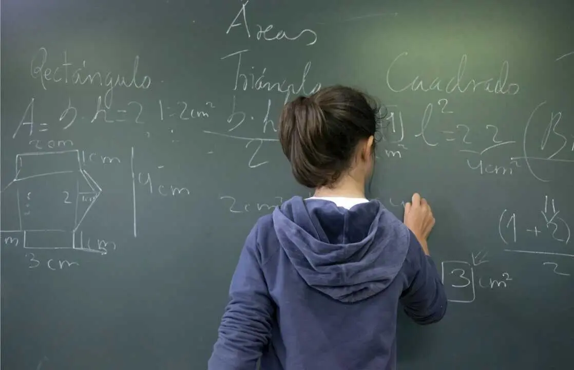  Archivo - Alumna escribe con tiza en una pizarra.<br>- XUNTA - Archivo 