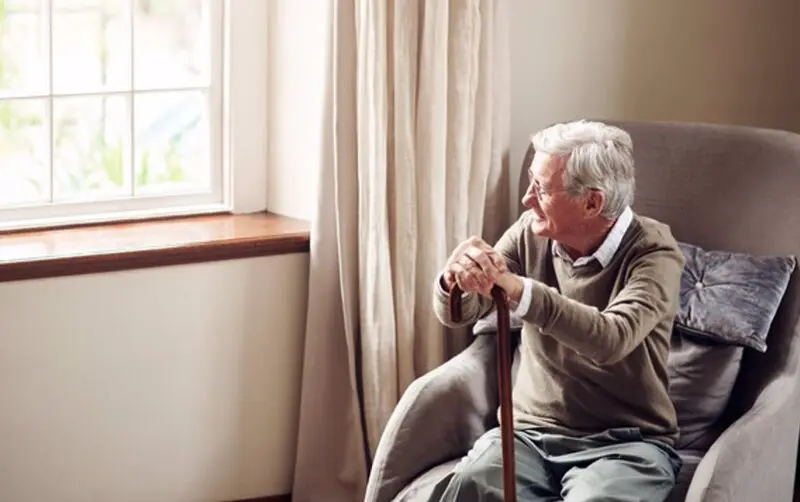  Archivo - Anciano sentado mirando por la ventana. - KUPICOO/ ISTOCK - Archivo 