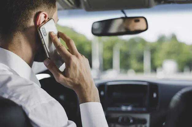  Distracciones al volante, persona usa un m&oacute;vil mientras conduce 