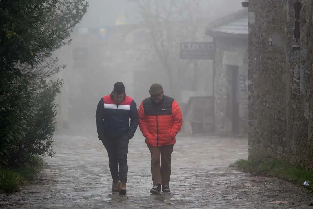 O Cebreiro, Pedrafita do Cebreiro, Lugo. Llega un frente frio que dejara nieve, lluvia y viento en el norte peninsular. En O Cebreiro, las temperaturas no han subido de los 3 grados y durante la noche ha caido una ligera nevada que no ha llegado a cuajar. En la imagen, dos hombres caminan entre la niebla en la aldea prerromana de O Cebreiro en la tarde del jueves 4 de noviembre