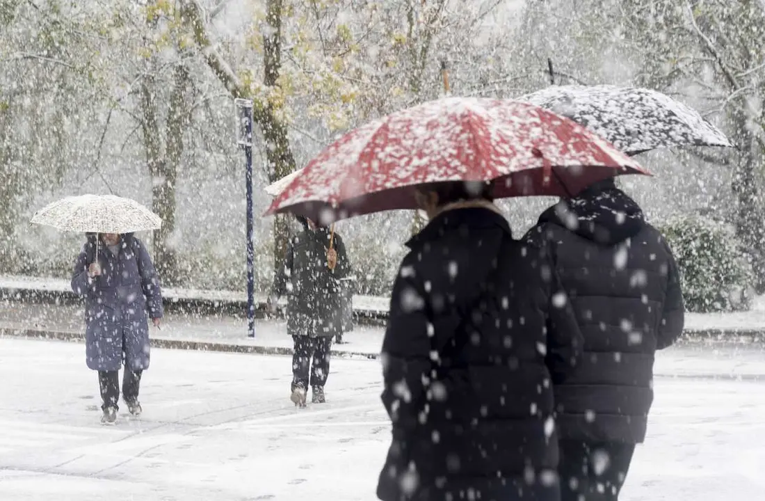 Paseantes cubiertos de nieve durante la llegada de una masa de aire &aacute;rtico, a 21 de noviembre de 2025, en Vitoria, Pa&iacute;s Vasco (Espa&ntilde;a).