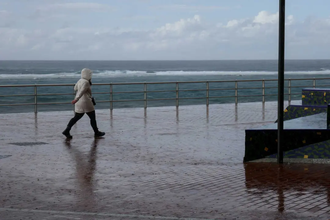 Archivo - Un hombre camina bajo la lluvia en Las Palmas de Gran Canaria, en Canarias (Espa&ntilde;a)