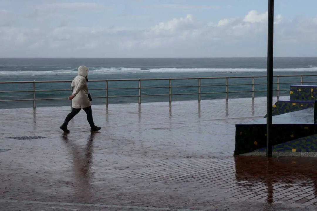   Archivo - Un hombre camina bajo la lluvia en Las Palmas de Gran Canaria, en Canarias (Espa&ntilde;a)  