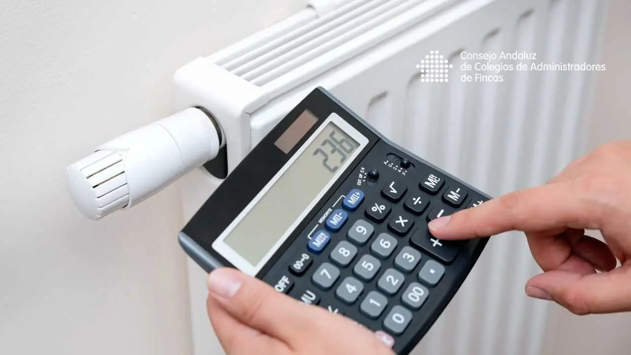 Archivo - Una persona hace cuentas con una calculadora frente a un radiador de calefacci&oacute;n.