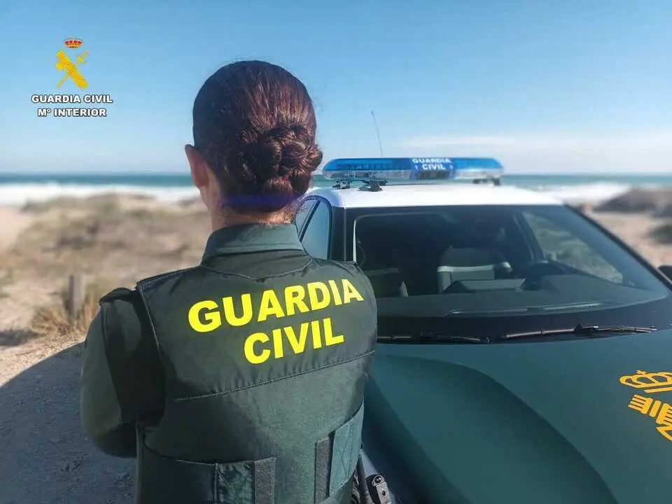   Agente de la Guardia Civil junto a un veh&iacute;culo  