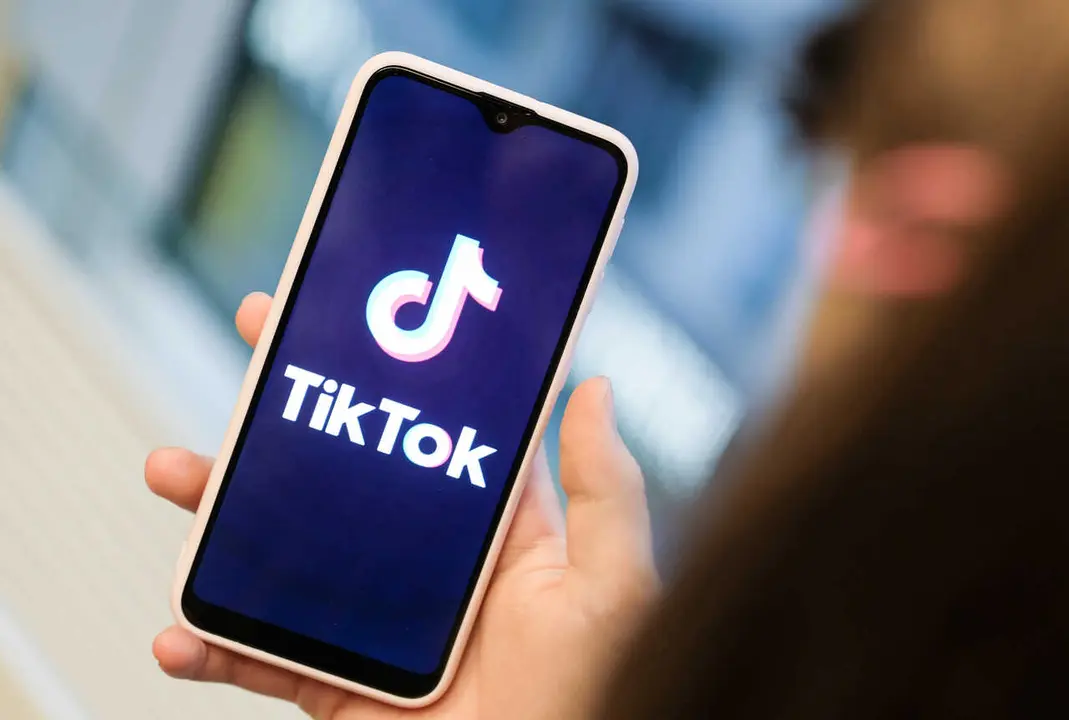 Archivo - FILED - 13 November 2019, Berlin: A girl holds a smartphone that displays a picture of short video app TikTok. the Beijing-based social media platform has apologized for removing a viral video criticizing the mass internment of Muslims in China.