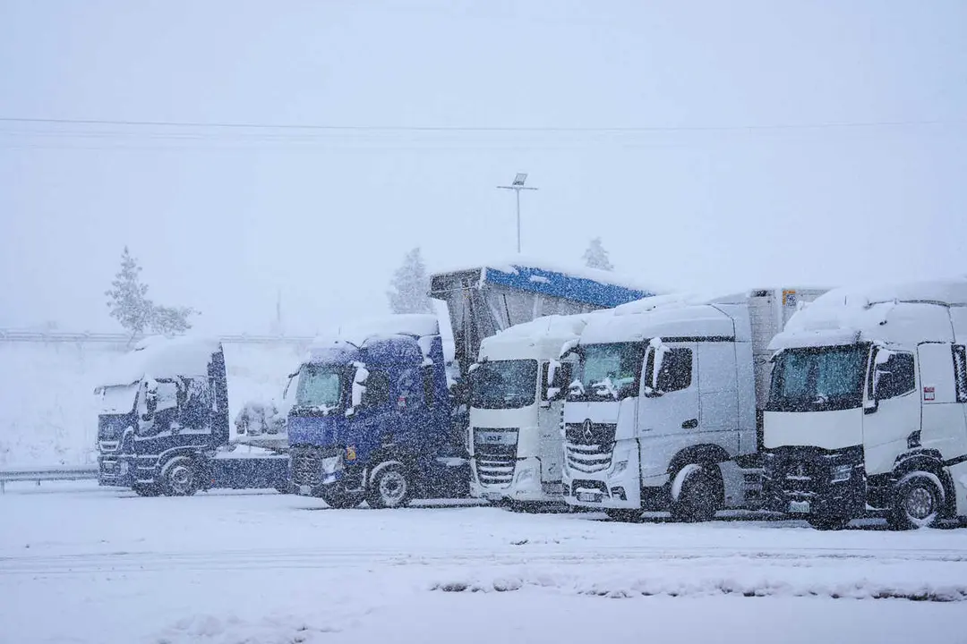 Archivo - Varios camiones parados por la nieve
