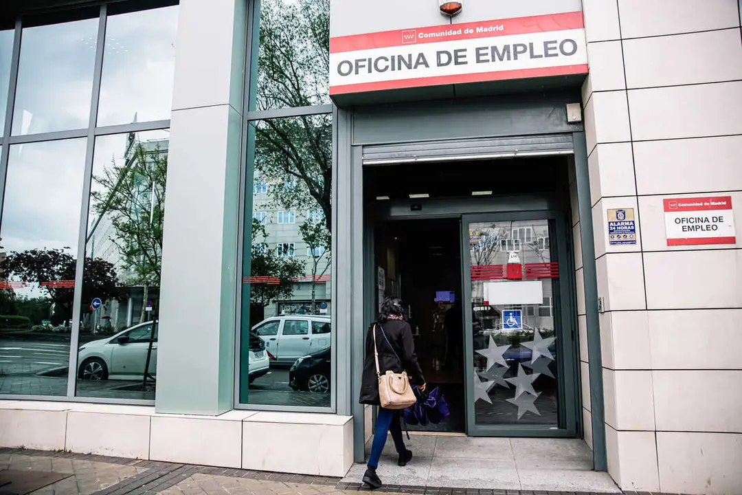 Archivo - Una mujer entrando en una oficina de empleo