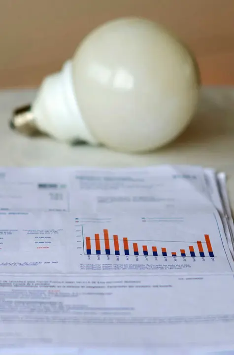 Archivo - Una factura de la luz y una bombilla