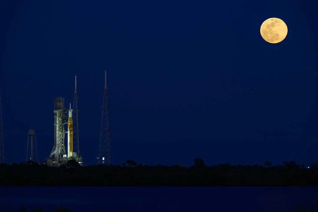 01 February 2026, US, Merritt Island: NASA's Space Launch System (SLS) rocket, with the Orion capsule atop, is seen on Launch Complex 39B, as the moon rises behind the rocket. A wet dress rehearsal is scheduled. A confirmed launch date will be decided bas