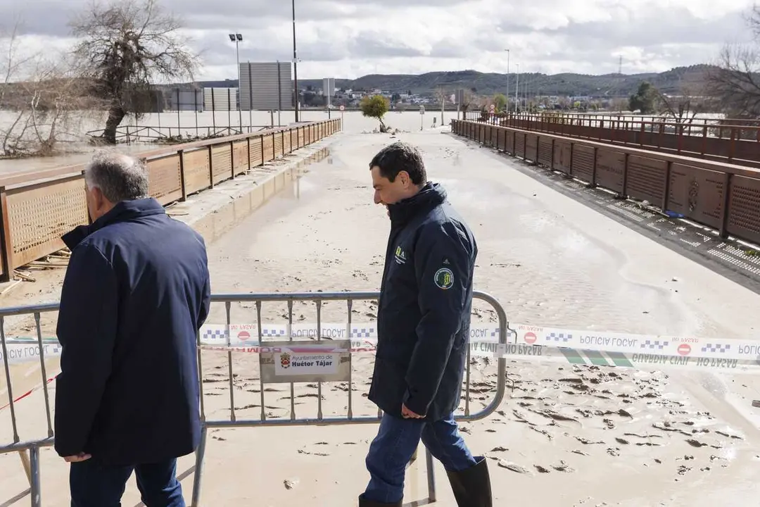 El presidente de la Junta de Andaluc&iacute;a, Juanma Moreno (d), visita este viernes 6 de febrero la localidad de H&uacute;etor T&aacute;jar, en la comarca granadina de Loja, gravemente afectada e incomunicada tras quedar rodeada por el agua tras desbordarse el r&iacute;o Genil.