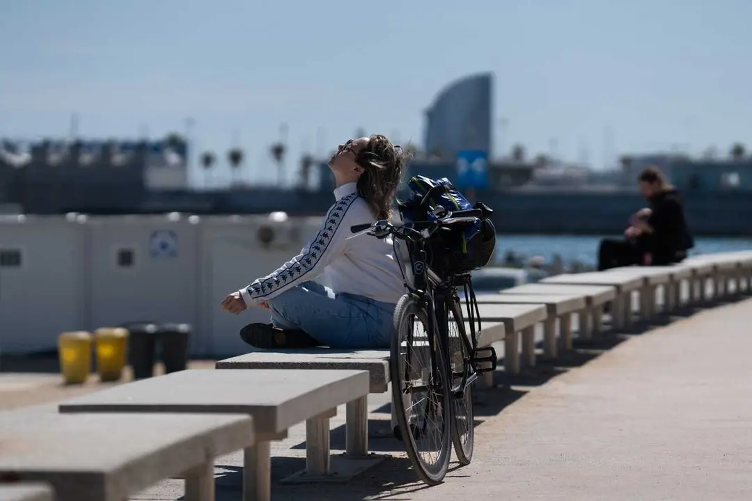 Archivo - Una mujer toma el sol en el paseo mar&iacute;timo de la playa del Bogatell, en Barcelona, Catalunya (Espa&ntilde;a). 