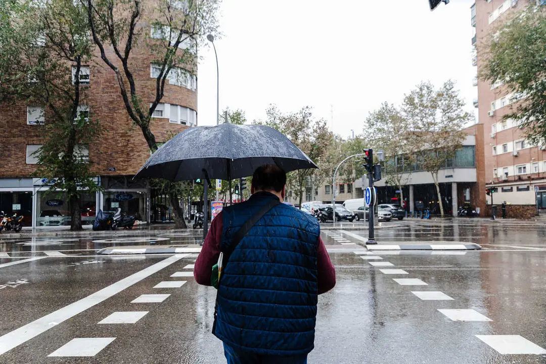 Archivo - Un hombre se protege de la lluvia con un paraguas, a 2 de noviembre de 2023, en Madrid (Espa&ntilde;a). La Agencia Estatal de Meteorolog&iacute;a (AEMET) ha activado la alerta roja en Madrid por fuertes vientos provocados por la borrasca Ciar&aacute;n. En la ma&ntilde;ana 