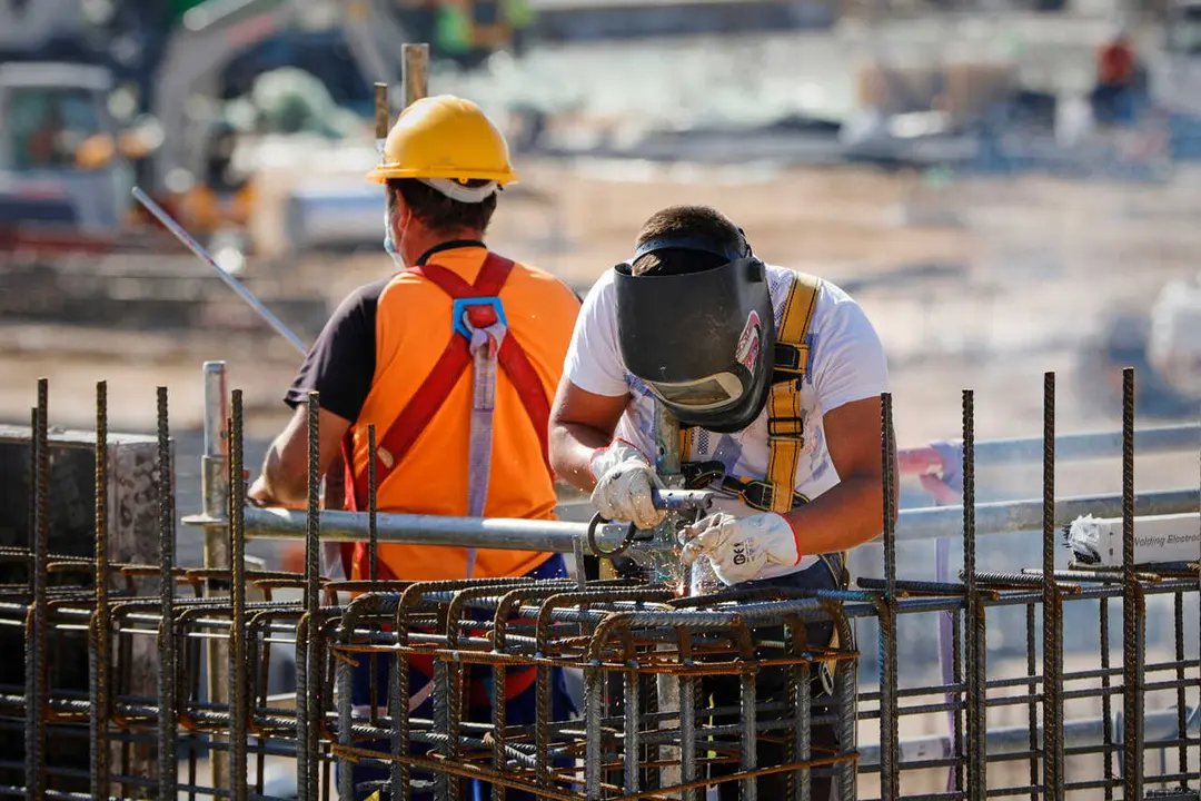 Archivo - Un soldador y un operario trabajando en una obra