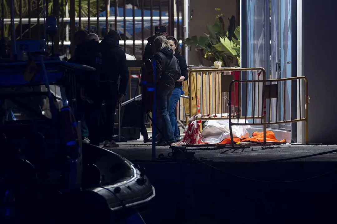 Varias personas junto al cad&aacute;ver aparecido en la playa del Somorrostro de Barcelona