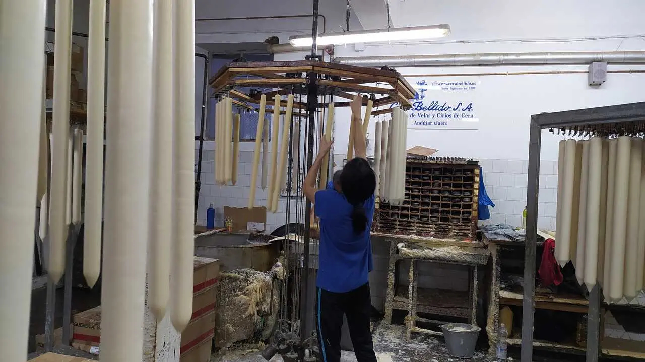 Archivo - Una trabajadora de Cera Bellido cuelga cirios.