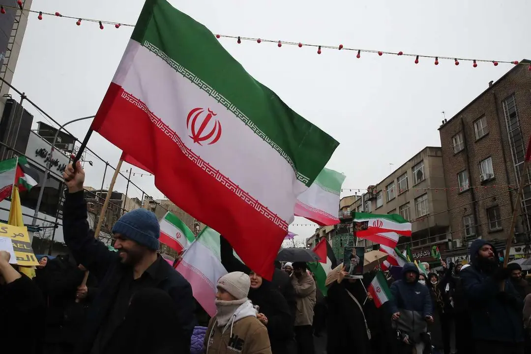 Un manifestante con una bandera de Ir&aacute;n en Teher&aacute;n