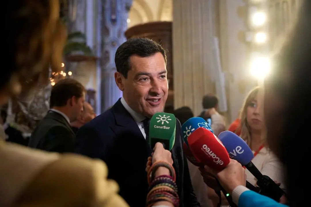 El presidente de la Junta de Andaluc&iacute;a, Juanma Moreno, atiende a los medios antes de la salida de La Borriquita en la iglesia de El Salvador de Sevilla.