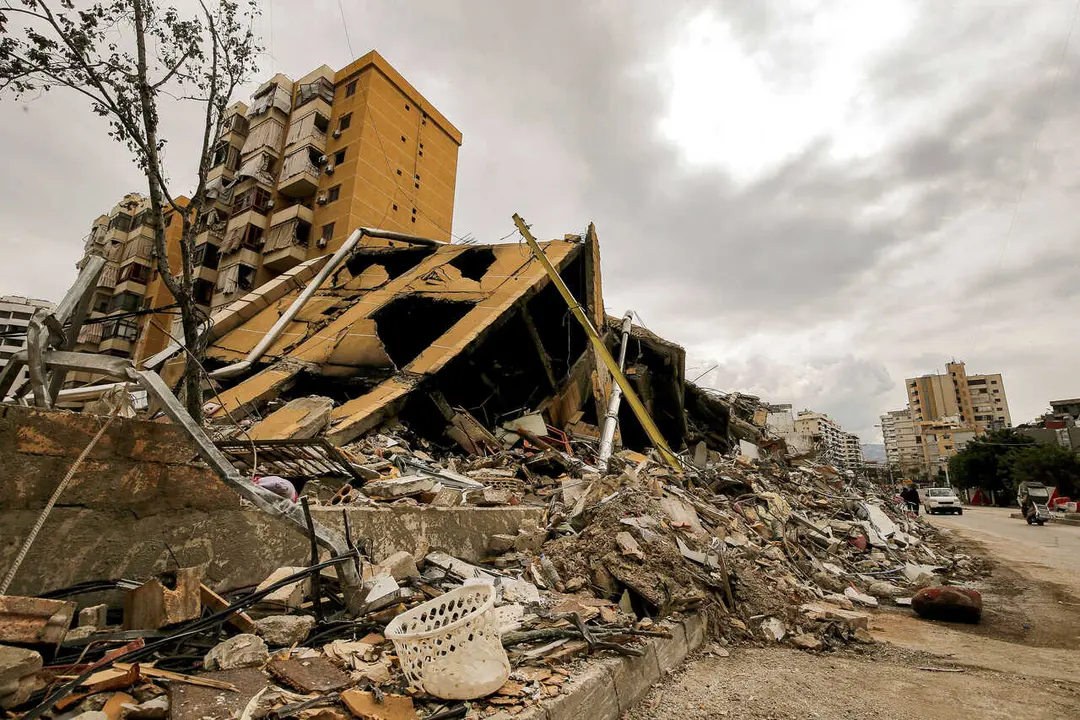 People walk past a destroyed building at the edge of the devastated Beirut southern suburb, a stronghold of pro-Iranian Hezbollah. Israel continued its attacks across Lebanon launching a fresh air strike south of Beirut. Lebanon was pulled into the Middle East war when Hezbollah began firing rockets into Israel on March 2 to avenge the killing of Iran&rsquo;s supreme leader Ali Khamenei.
