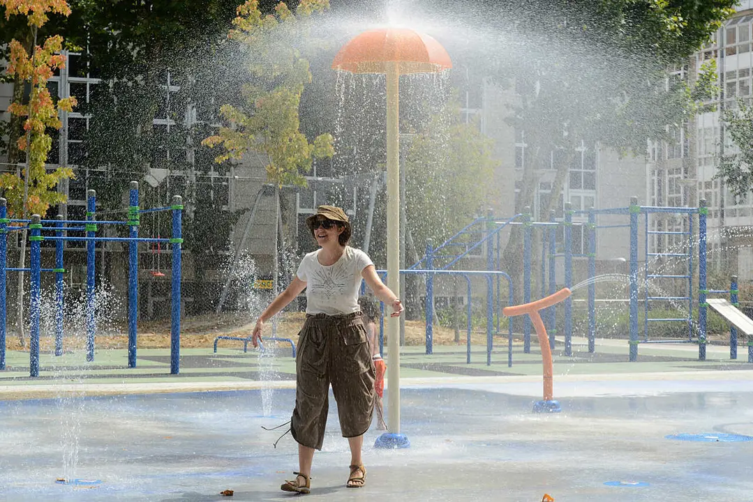 OLA DE CALOR EN OURENSE, UNA SEMANA. FUENTE DE CHORROS EN EL PARQUE INFANTIL "ALAMEDA DO CRUCEIRO", EN EL CENTRO DE LA CIUDAD, UNA DE LAS DOS QUE TIENE ACTIVADOS LOS CHORROS DE AGUA EN TODA LA CIUDAD. VISITANTE PROCEDENTE DE CATALU&Ntilde;A SE REFRESCA.OURENSE 14/07/22. FOTO ROSA VEIGA