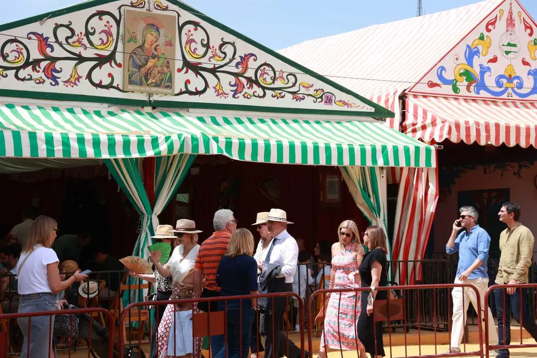 Varias personas pasean por el Real en la Feria de Abril.