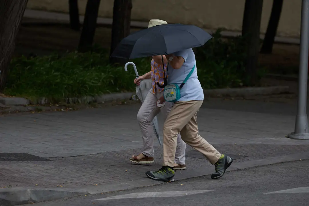 Archivo - Dos personas se protegen de la lluvia con un paraguas, a 8 de junio de 2024, en Madrid (Espa&ntilde;a). 