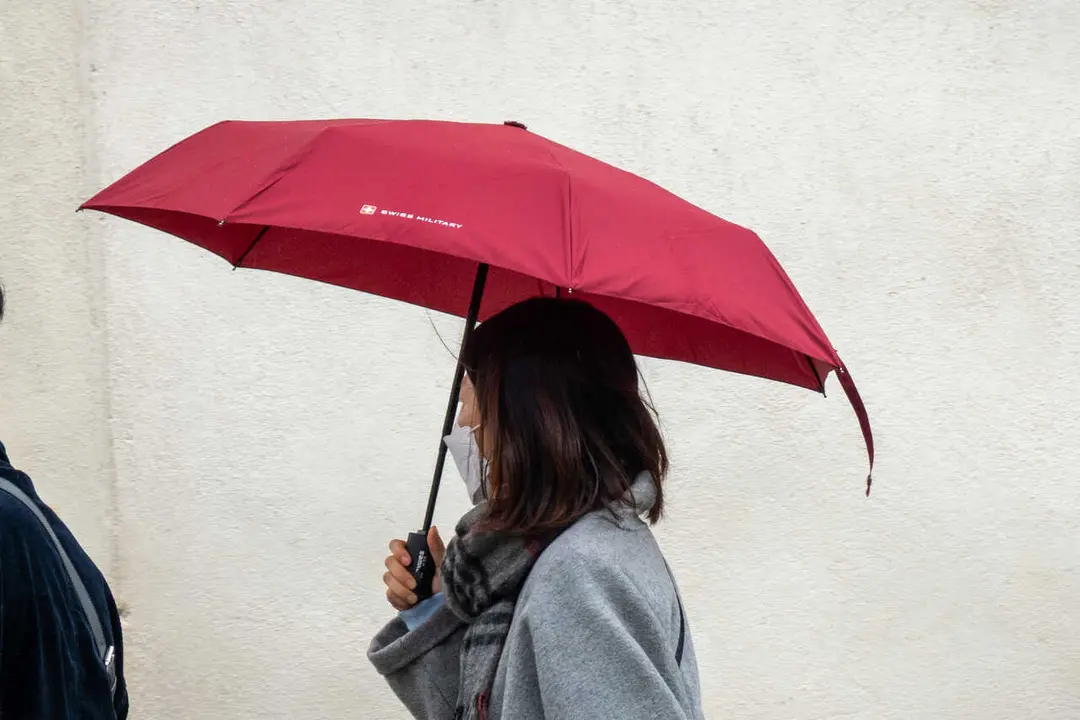 Turistas con paraguas por el centro de la ciudad  durante la llegada de una nueva borrasca que trae polvo en suspensi&oacute;n. A 07 de abril del 2026 en Sevilla, Andaluc&iacute;a (Espa&ntilde;a). 