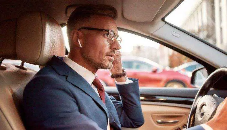 Hombre conduciendo con air pods