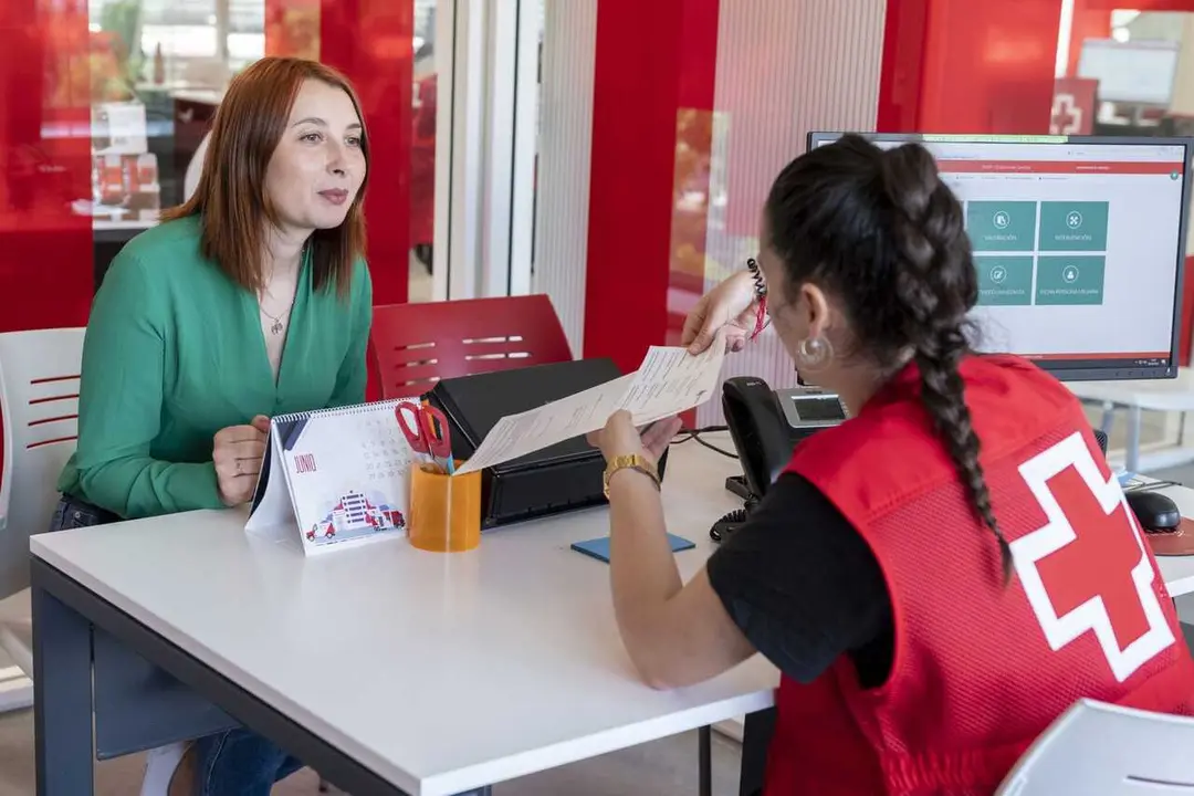 Personal de Cruz Roja asesora a una mujer en materia de empleo.