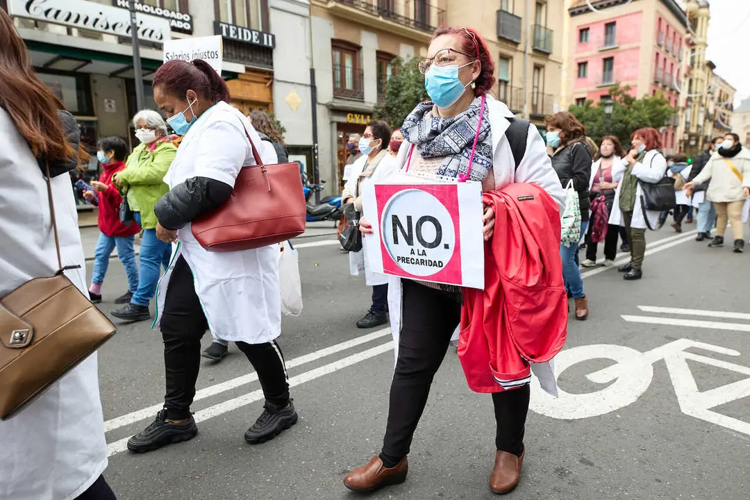 Archivo - Una mujer sostiene una pancarta donde se lee 'No a la precariedad', en una manifestaci&oacute;n de profesionales sociosanitarias, a 21 de noviembre de 2021, en Madrid (Espa&ntilde;a). 