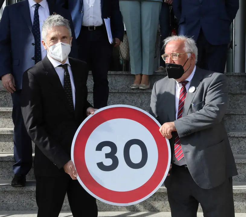 Archivo - El ministro del Interior, Fernando Grande-Marlaska (i) y el director general de Tr&aacute;fico, Pere Navarro (d) posan con una se&ntilde;al durante la inauguraci&oacute;n de la Jornada de la Direcci&oacute;n General de Tr&aacute;fico (DGT) sobre la implantaci&oacute;n de los 30 km/h en 