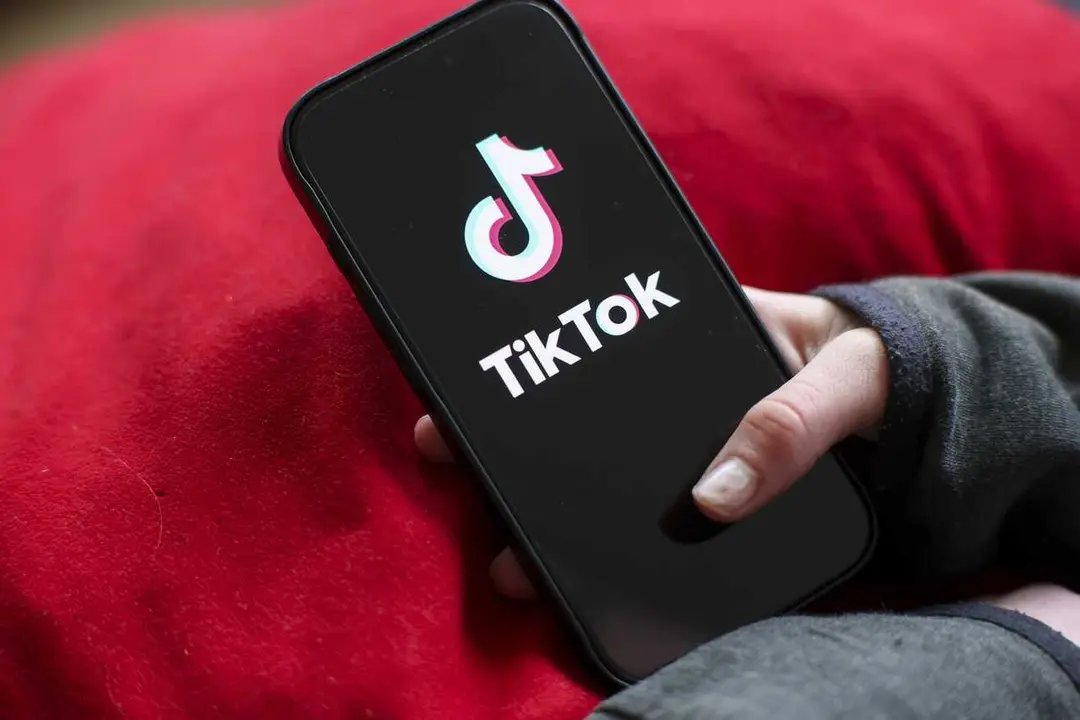 Archivo - A girl holds an iPhone 16 with the logo of the TikTok app on it. 