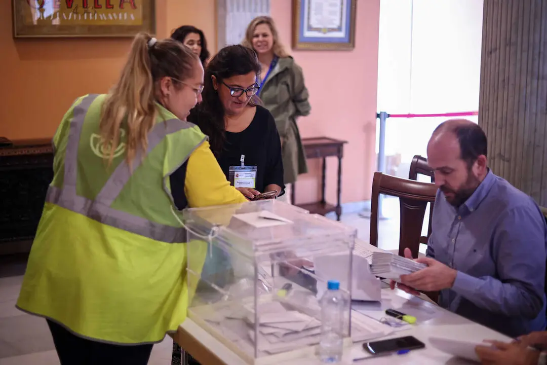 Archivo - Una integrante de Correos llega a la mesa electoral para entregar los votos ejercido por este m&eacute;todo en Sevilla, en una imagen de archivo