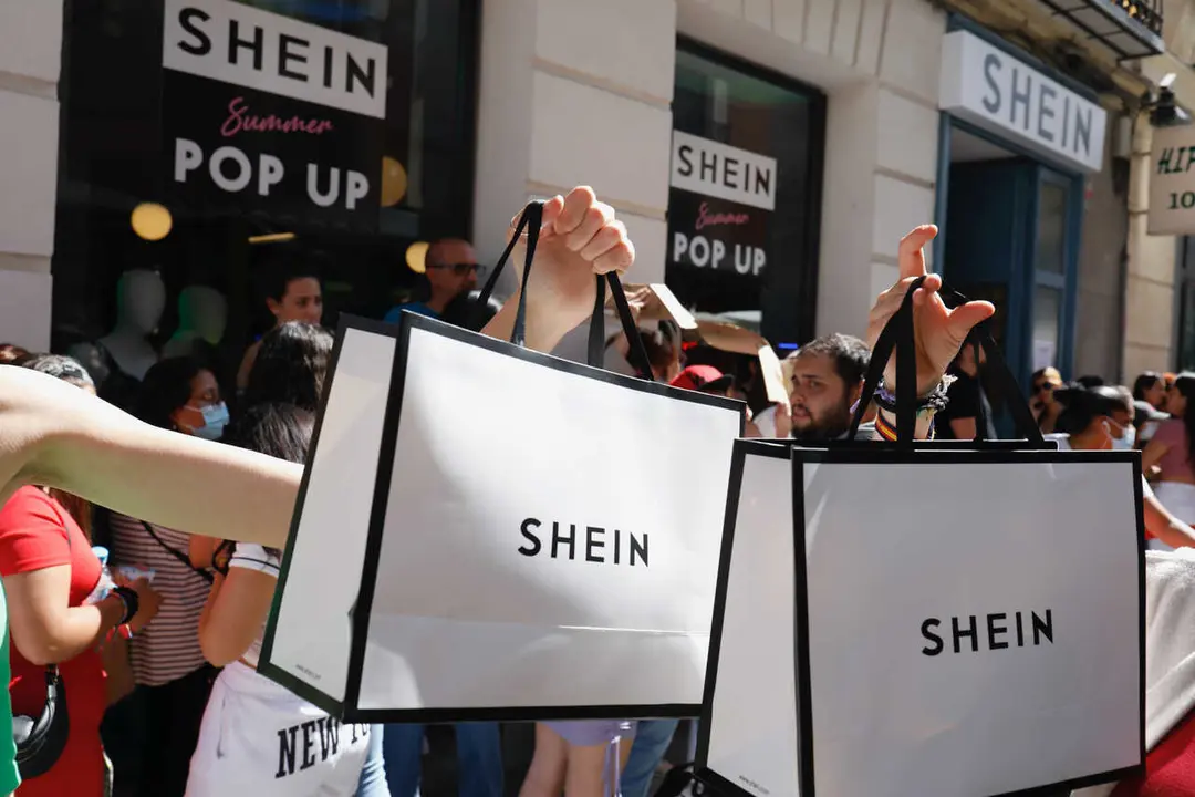 Archivo - Dos personas sujetan dos bolsas de Shein despu&eacute;s de entrar a la primera tienda f&iacute;sica de SHEIN en Madrid, a 2 de junio de 2022, en Madrid (Espa&ntilde;a). 