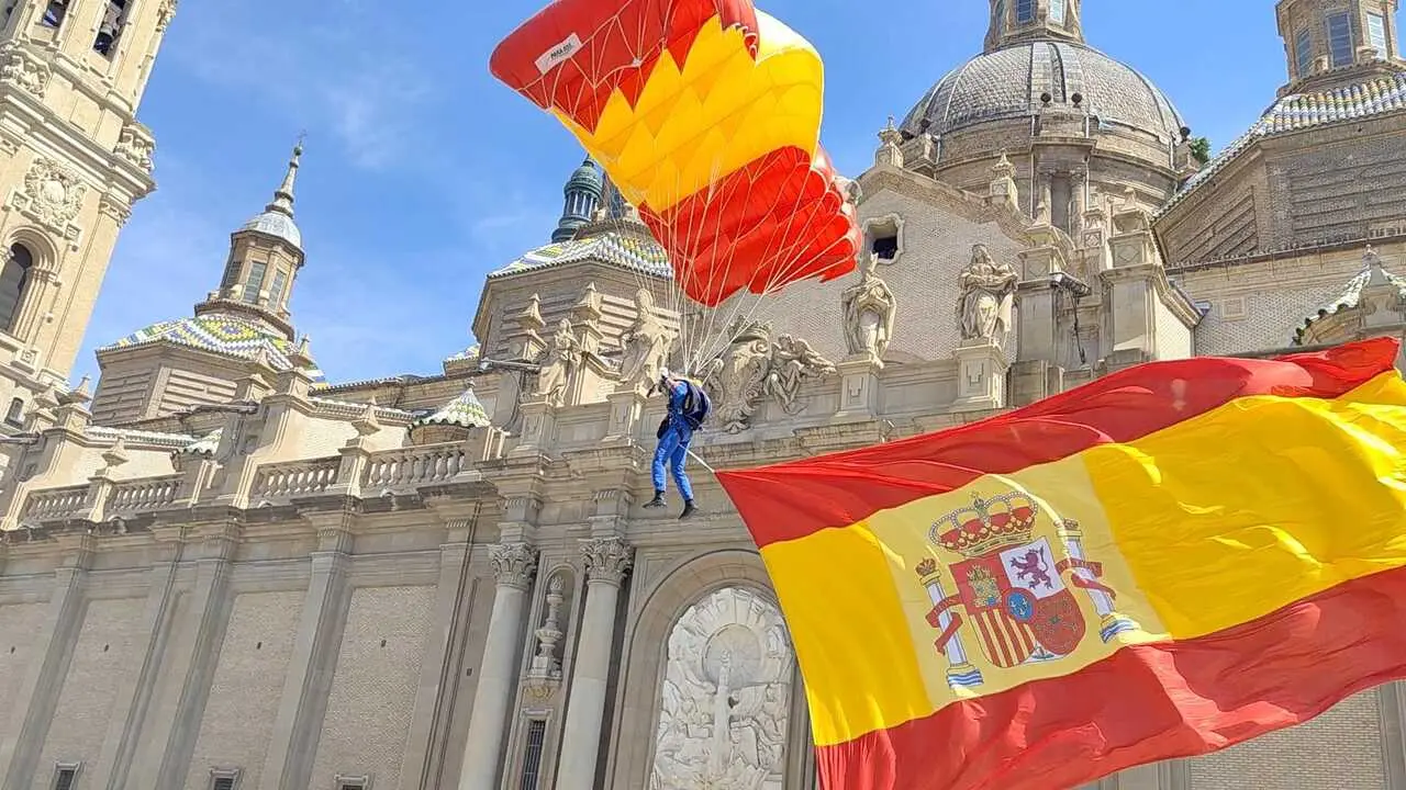 El eargento primero Pablo Garc&iacute;a Matanza toma tierra en la plaza del Pilar portando la bandera de Espa&ntilde;a en el acto del D&iacute;a de las Fuerzas Armadas.