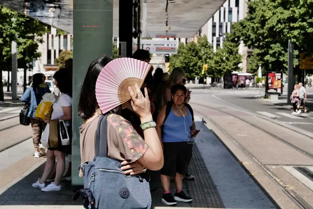 Archivo - Una mujer se tapa del sol con un abanico en la parada del tranv&iacute;a del Paseo de La Independencia, a 10 de julio de 2023, en Zaragoza, Arag&oacute;n (Espa&ntilde;a). 