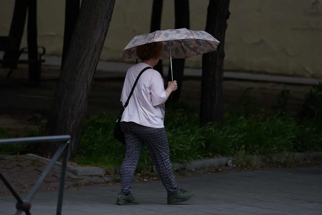 Archivo - Una mujer se protege de la lluvia con un paraguas, a 8 de junio de 2024, en Madrid (Espa&ntilde;a). 